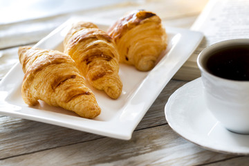 Croissants with coffee on the wooden table 
