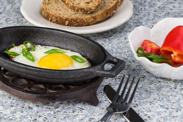 Fried egg for breakfast in  individual iron skillet.