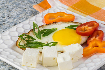 Breakfast with fried egg, fresh vegetables and feta.