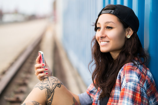 attraktive junge tätowierte Frau mit Smartphone