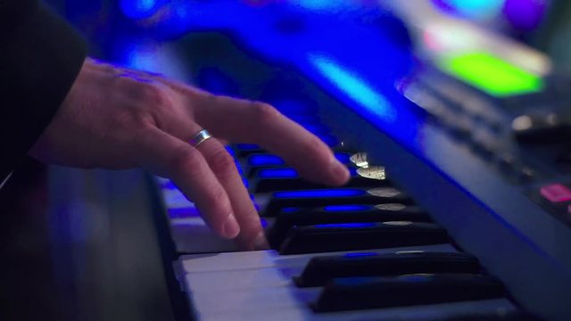 Man Play on Electric Piano Colorful Light.