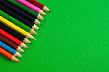 Coloring pencils isolated on a green background