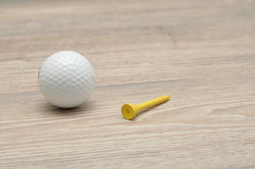 A golf ball with tee's isolated on a wooden background