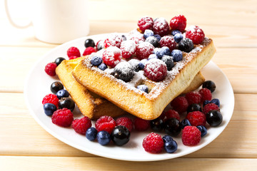 Breakfast waffles with fresh berries and coffee mug