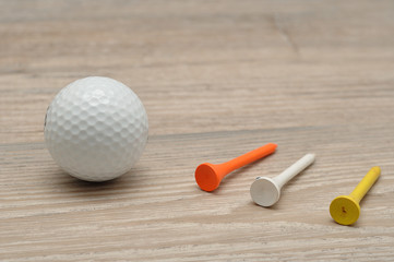 A golf ball with tee's isolated on a wooden background