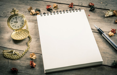 Empty notepad for your content, pen and vintage old pocket watch on wooden background