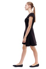 Fototapeta premium back view of walking woman. beautiful girl in motion. Isolated over white background. Blonde in a short black dress out of the frame.
