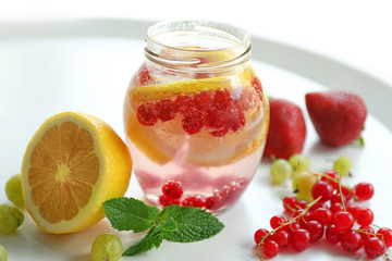 Refreshing water with fruits on table