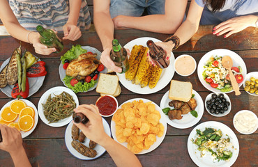 Friends eating and drinking on picnic