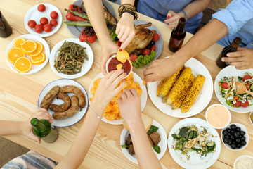 Friends passing bowl with sauce on picnic