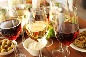 Glasses of different wine on wooden table