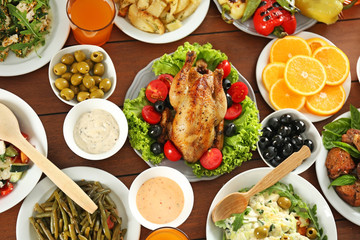Plates with different salads and meat on table