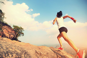 young fitness woman runner running on mountain peak