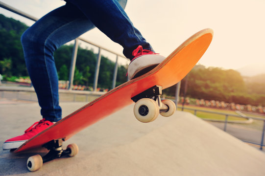 young skateboarder legs skateboarding at skatepark