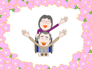 満開の桜の中を散歩する高齢者