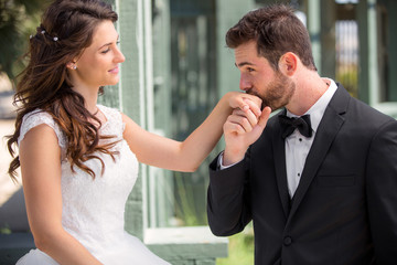 Gentleman groom kisses hand of wife newlyweds laugh and love bride fun