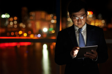 Businessman working on digital tablet s night