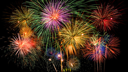 Colorful firework celebration on dark night sky background.