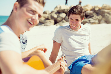 Beautiful young people with guitar on beach