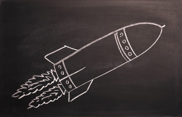 Start up concept with a rocket on a blackboard