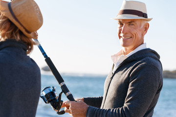Senior man fishing with his grandson