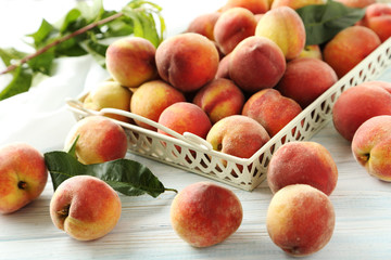 Sweet peach fruit in tray on white wooden table