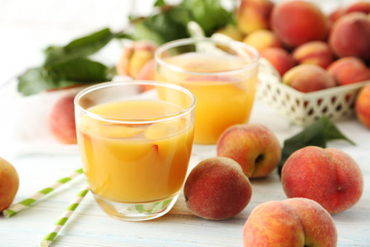 Glasses of peach juice on white wooden table