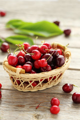 Fototapeta na wymiar Ripe cherries in basket on a grey wooden table