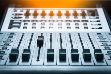 digital music studio mixer, shallow dept of field & focus on third track fader for recording or TV...