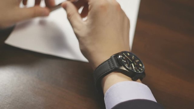 Businessman checking wrist watch. The watch on the hand
