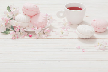 Red tea with flowers on white wooden background