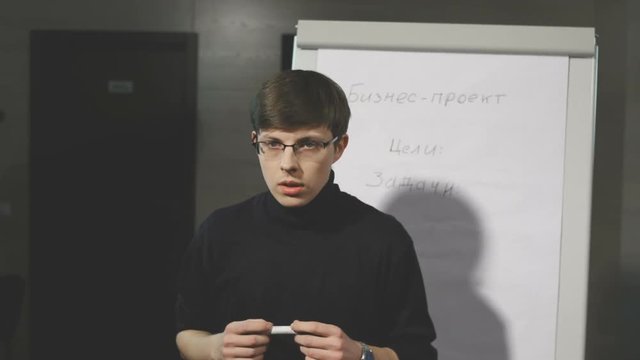 Young man making a presentation about the flip-chart.