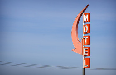 aged and worn vintage neon motel sign with arrow