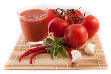 tomatos with glass of juice isolated on white background
