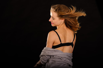 Naklejka premium Young slim model posing in underwear on black background