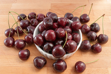 cherries in a white bowl on the wood tabel