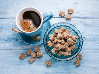 Cup of coffee and cane sugar cubes.