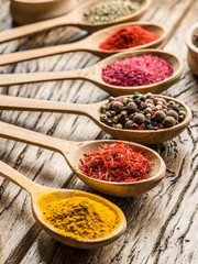 Assortment of colorful spices in the wooden spoons.