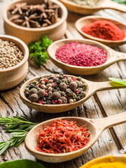 Assortment of colorful spices in the wooden spoons.