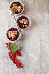 Ready berry cheesecake in a plastic jar with  white and red curr