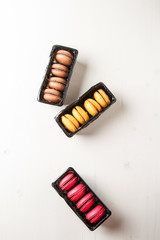 French dessert. Macarons with cocoa, strawberry and lemon in a b