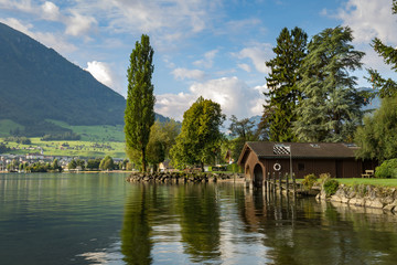 Naklejka premium Picturesque wooden boat house on a lake shore