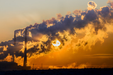 Fototapeta premium The setting sun makes its way through the dense smoke