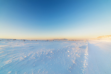 Obraz premium Winter road in snow-covered desert rock.