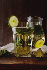 Mint iced tea with lime in the glass. Dark background.