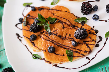 Delicious pancakes with blackberries and chocolate.