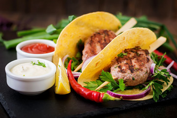 Tortillas tacos with appetizing kebab (meatballs) and sauce on black background