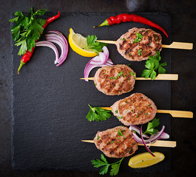 Appetizing kofta kebab (meatballs) on black background. Top view