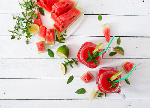 Fresh watermelon smoothies with lime and mint on white wooden background. Top view