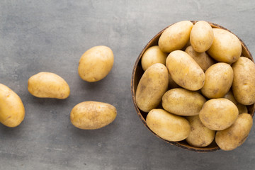New potato on the bowl, gray background.